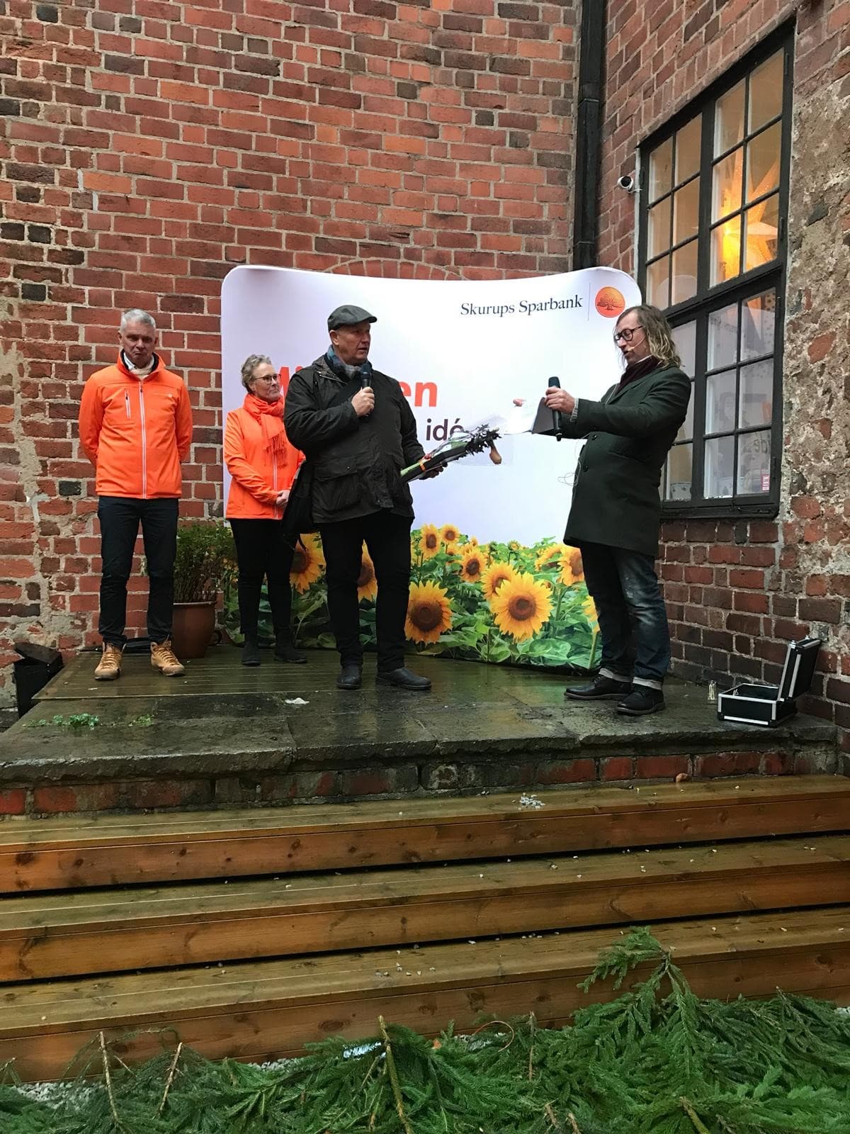 Prisutdelning på scen framför en banderoll från Skurups Sparbank
